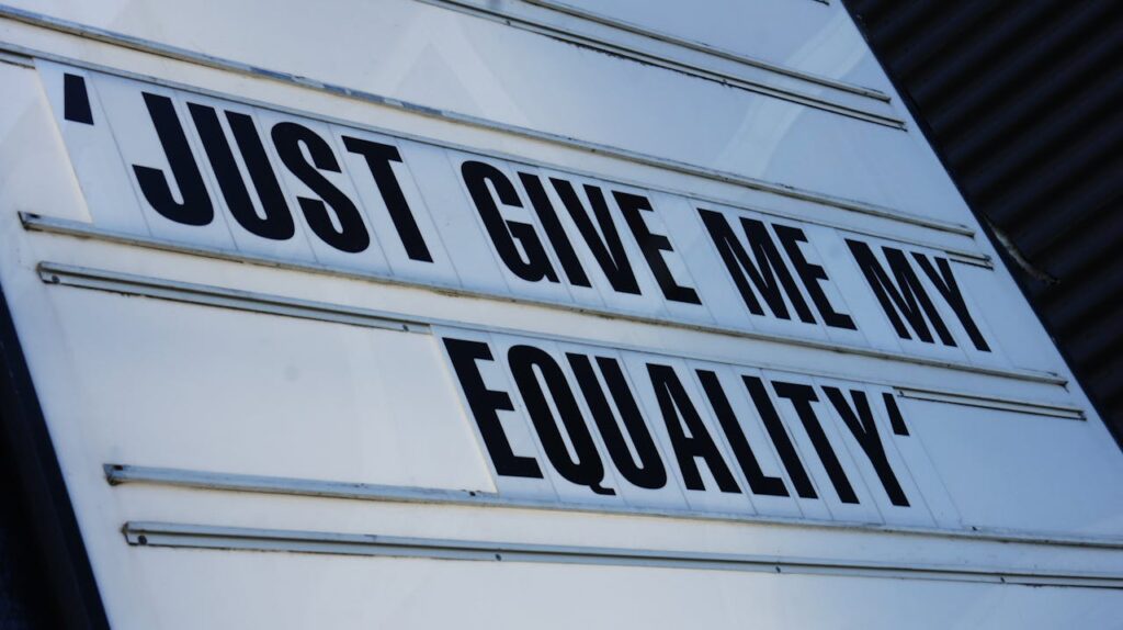 Close-up of a signboard displaying 'Just Give Me My Equality',' message about equality and rights.